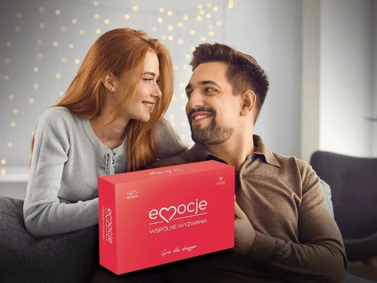 Para z uśmiechem na twarzy trzyma pudełko gry 