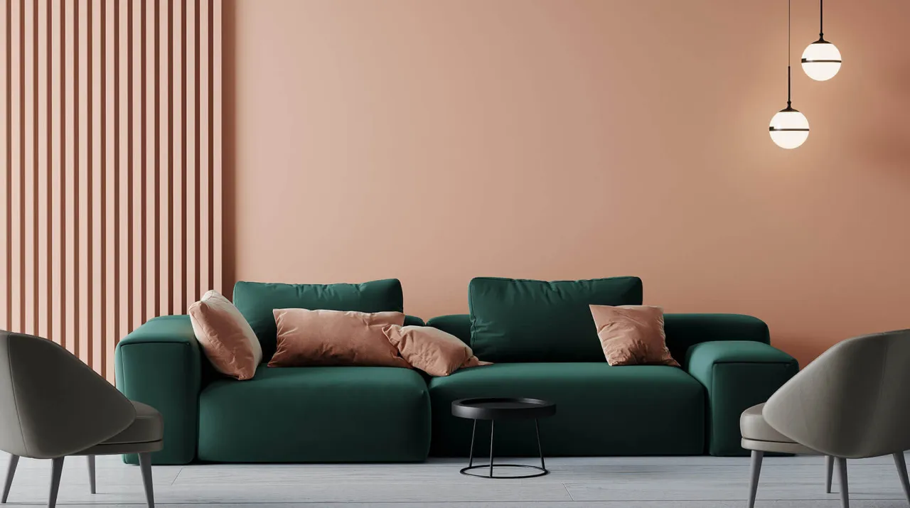 Nowoczesny salon z zieloną kanapą, różową ścianą i ozdobnymi listwami na ścianie.
