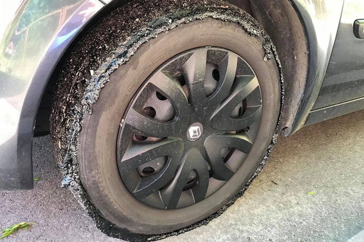 Opona samochodu z plamami smoły