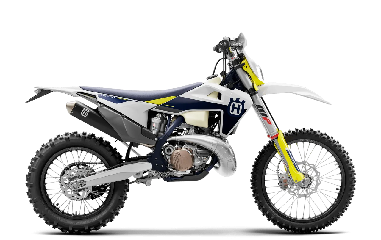 Husqvarna 250 Enduro gotowy do podboju terenu. Biało-granatowy motocykl z żółtymi akcentami.