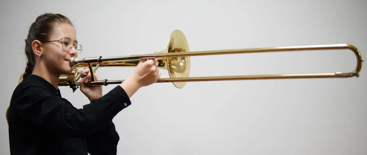 Puzonista grający na puzonie w orkiestrze