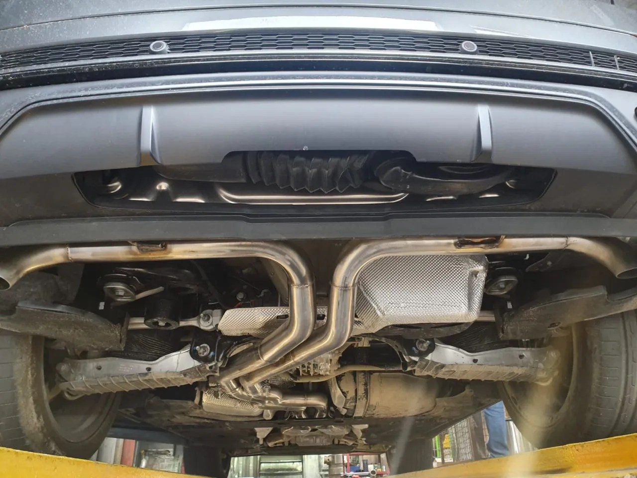 Widok od spodu samochodu, gdzie widać układ wydechowy. Katalizator służy do oczyszczania spalin.