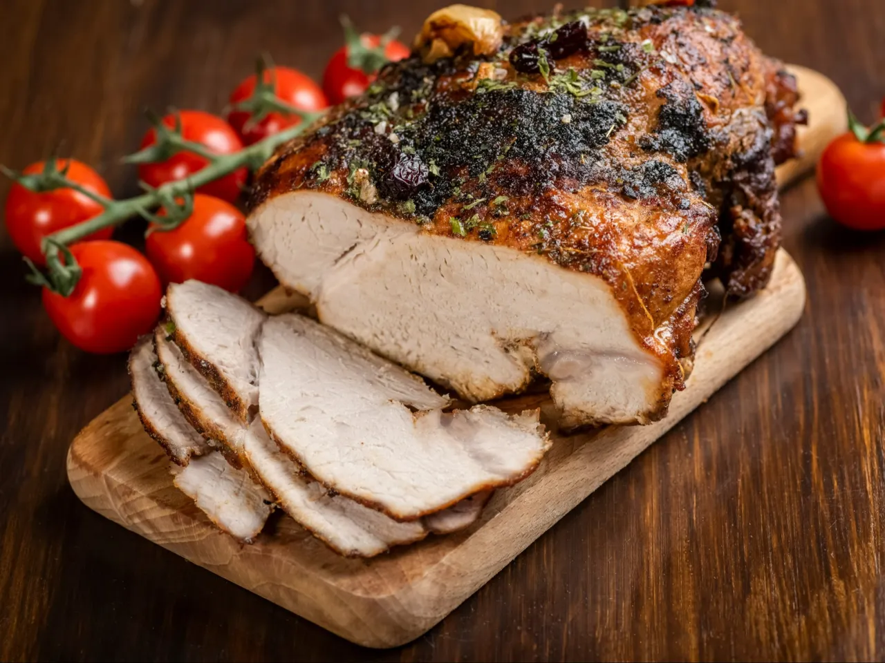 Soczysta pieczona szynka wieprzowa z ziołami na desce