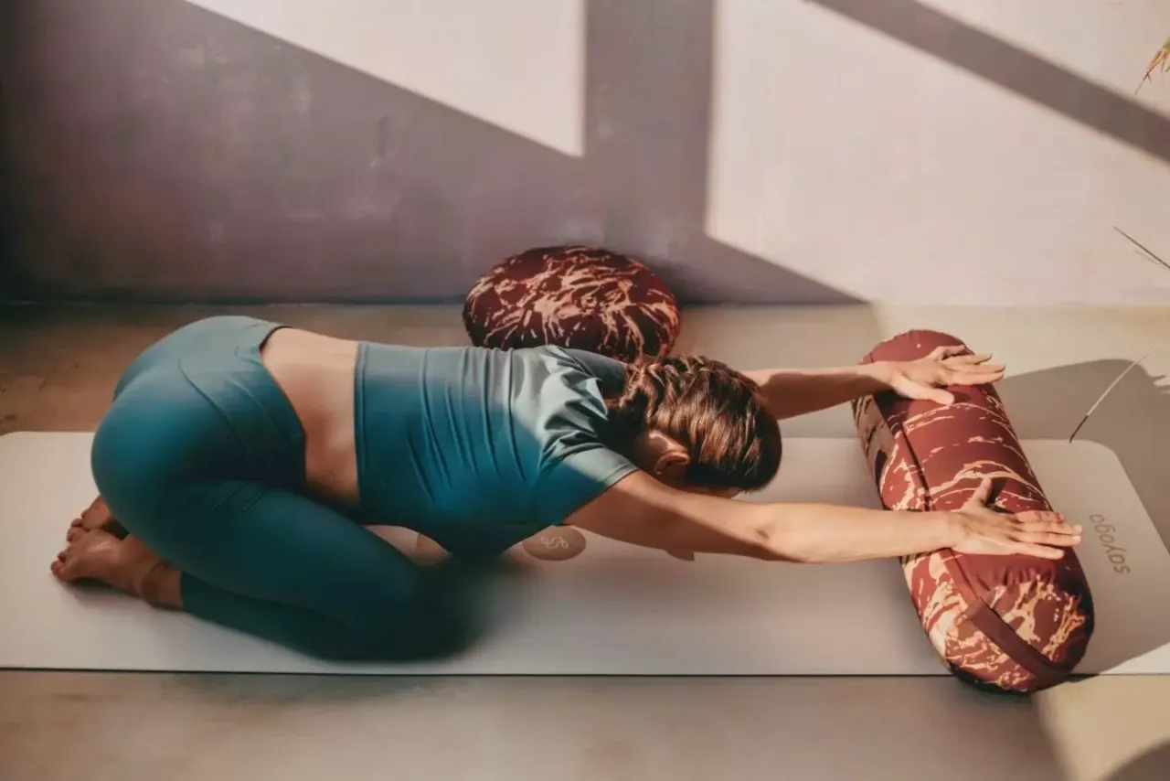 Kobieta wykonująca delikatne ćwiczenia jogi, np. pozycja dziecka