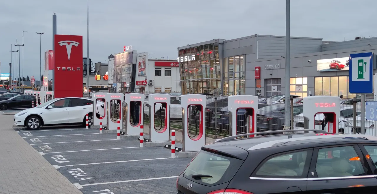 Stacja ładowania Tesli z kilkoma samochodami. Zastanawiasz się, ile trwa ładowanie Tesli? Tutaj możesz się dowiedzieć.