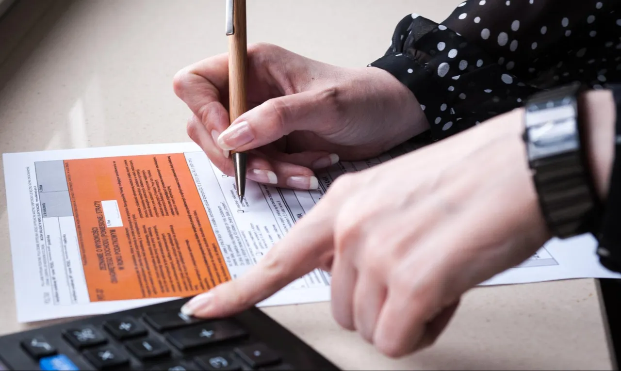 Osoba zmartwiona dokumentami podatkowymi lub symbolizująca błędy w rozliczeniach