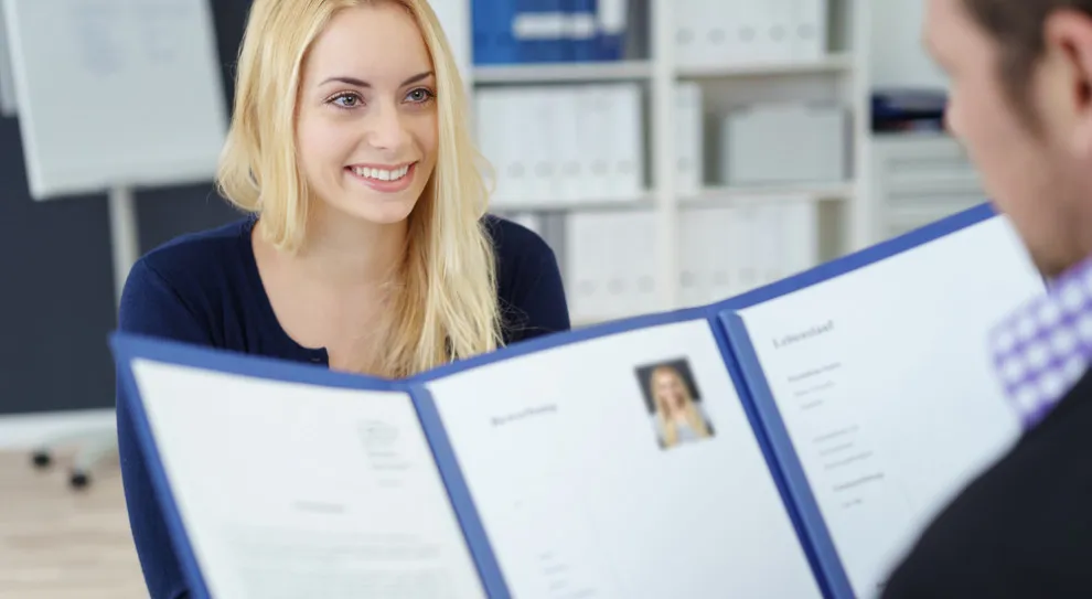 osoba wręczająca CV na rozmowie kwalifikacyjnej