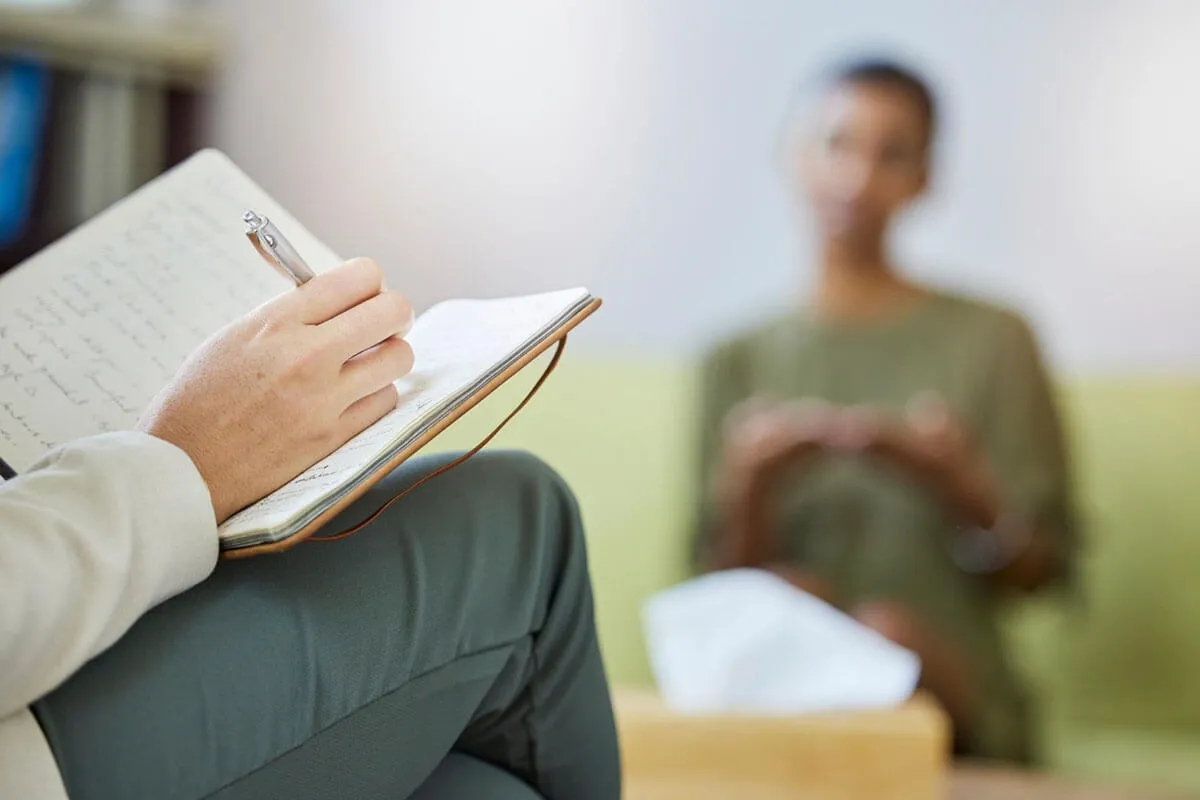 osoba pisząca w dzienniku, terapia poznawczo-behawioralna