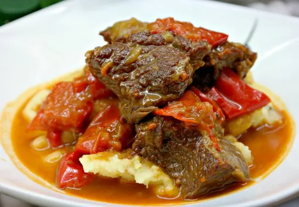 Składniki na gulasz: surowe mięso, cebula, papryka, przyprawy