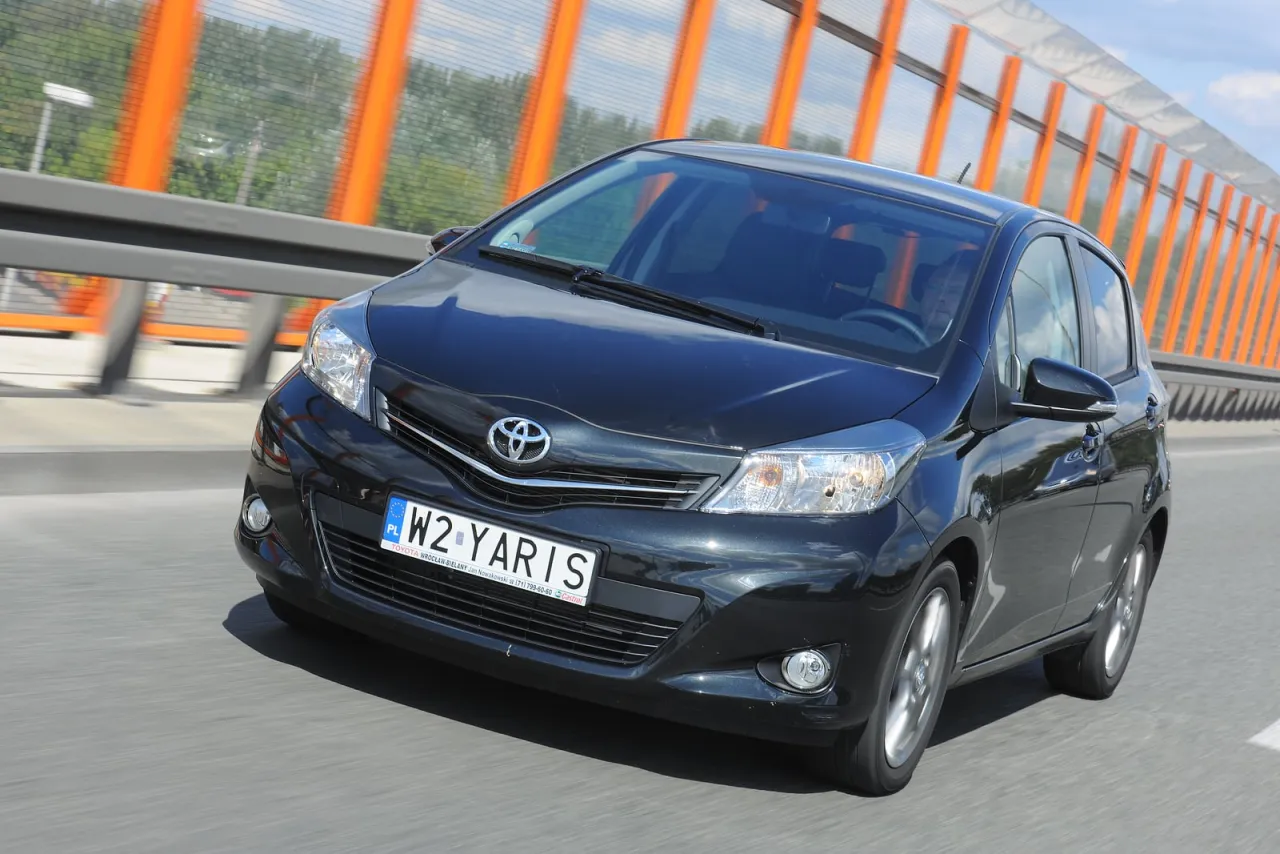 Czarny Toyota Yaris 1.4 D4D w ruchu. Zastanawiasz się nad pojemnością baku? Ten model oferuje świetne osiągi i ekonomiczne spalanie.