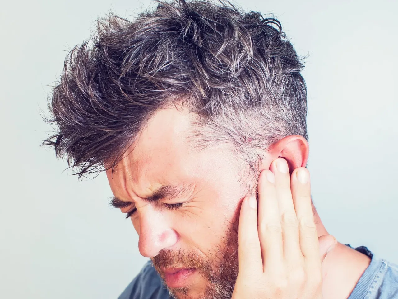 Mężczyzna z bólem ucha, szuka informacji: co na zapalenie ucha bez recepty.