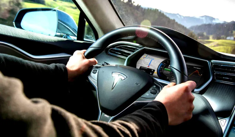 kierowca trzymający ręce na kierownicy autopilot