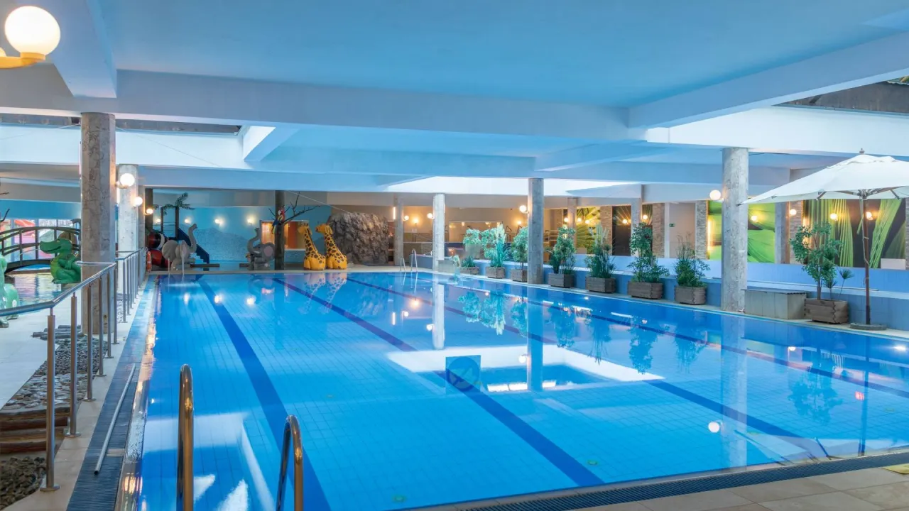 Karpacz noclegi z basenem i wyżywieniem: kryty basen z atrakcjami dla dzieci, jak zjeżdżalnie i figurki zwierząt. Idealne miejsce na rodzinny wypoczynek.