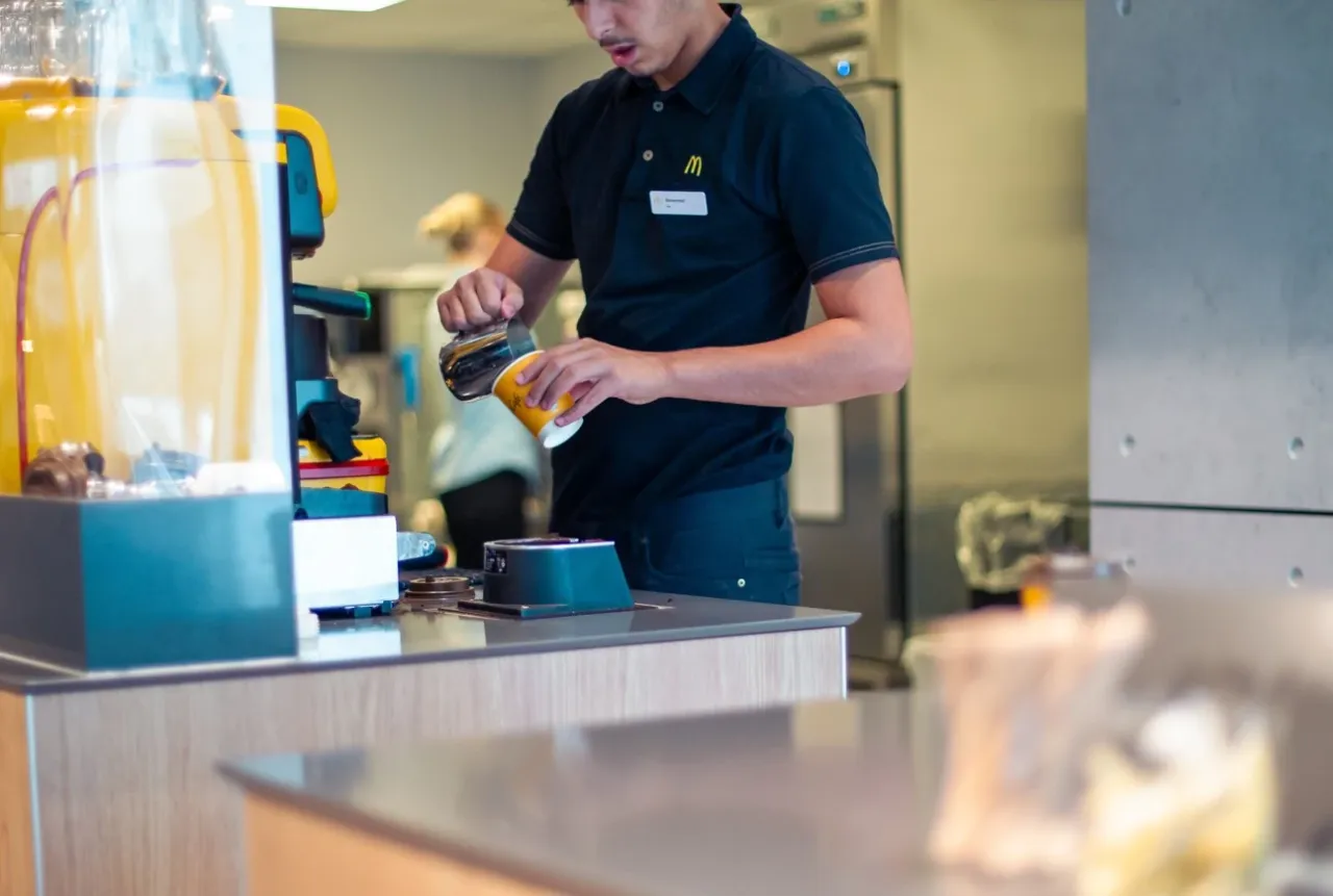 Pracownik McDonald's przygotowuje kawę. Czy zastanawiałeś się, ile zarabia pracownik McDonald's?