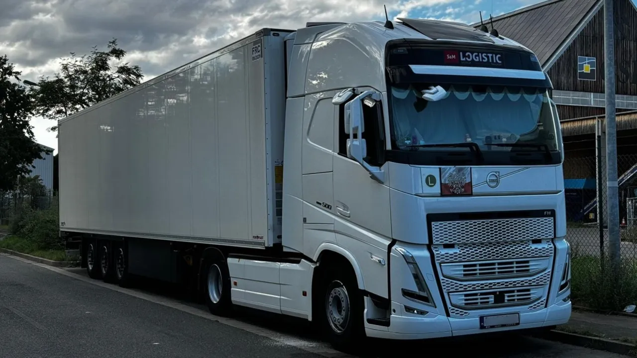 Biały Volvo FH z naczepą, idealny do transportu. Zastanawiasz się, jakie prawo jazdy na tira jest potrzebne, by nim kierować?