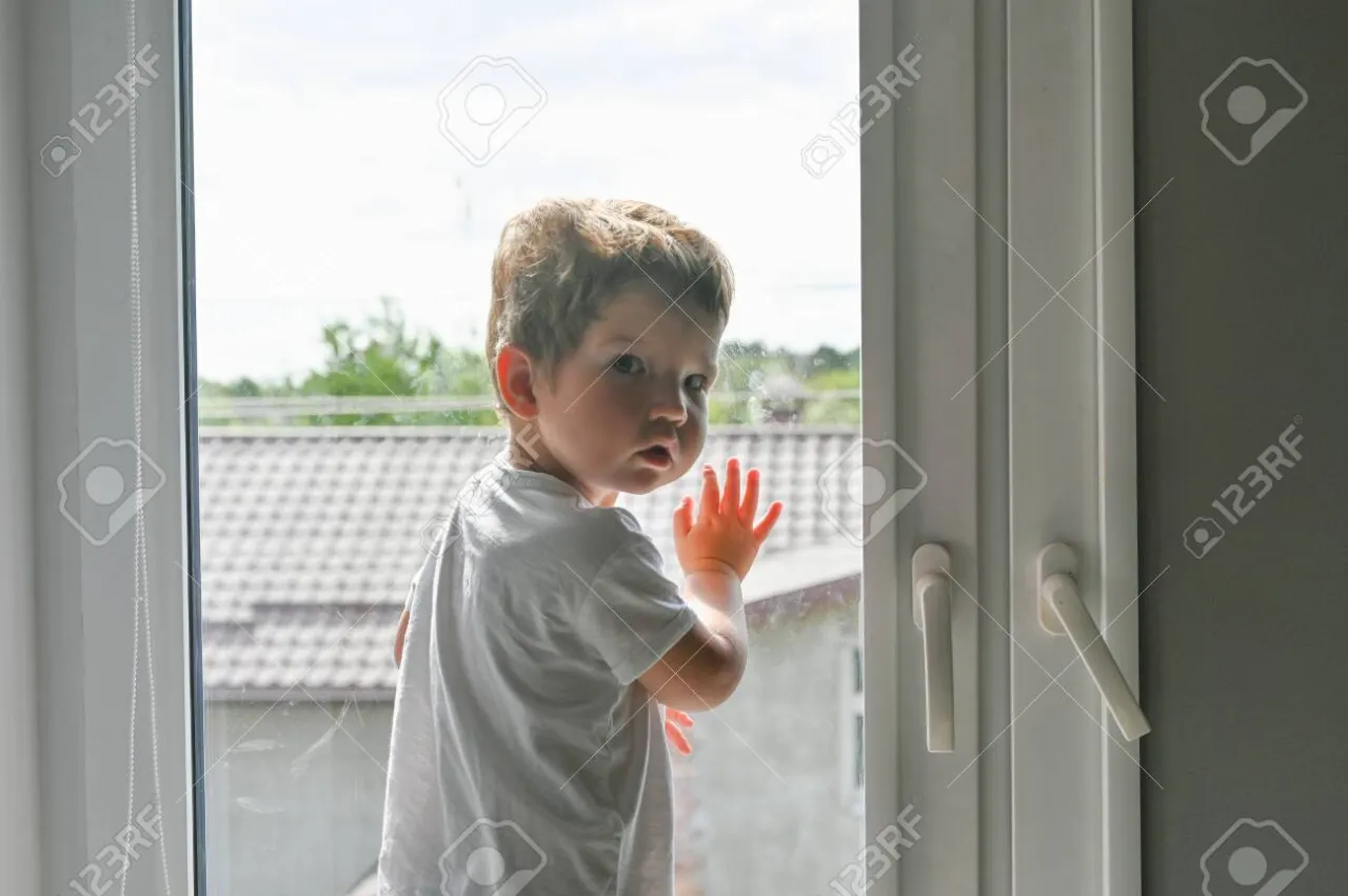 smutne zamyślone dziecko patrzące przez okno