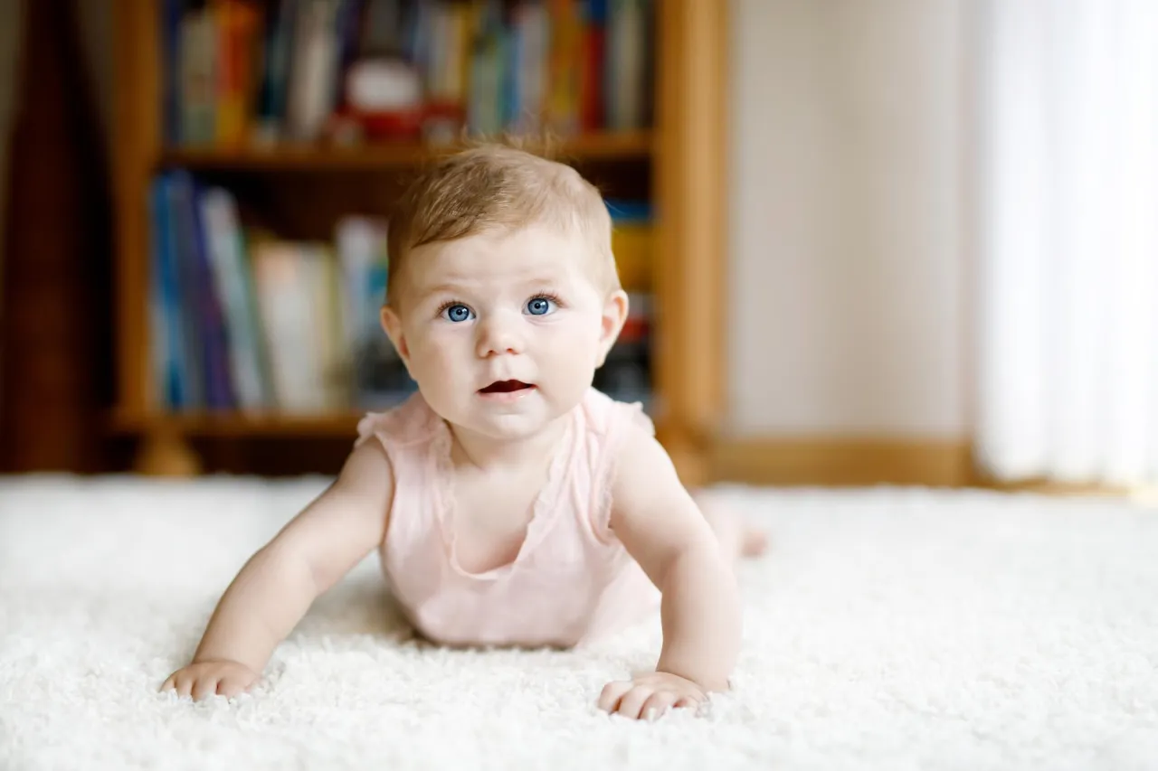 Uśmiechnięte niemowlę z rodzicem, skok rozwojowy