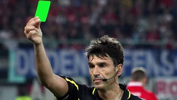 Sędzia pokazujący zieloną kartkę w siatkówce