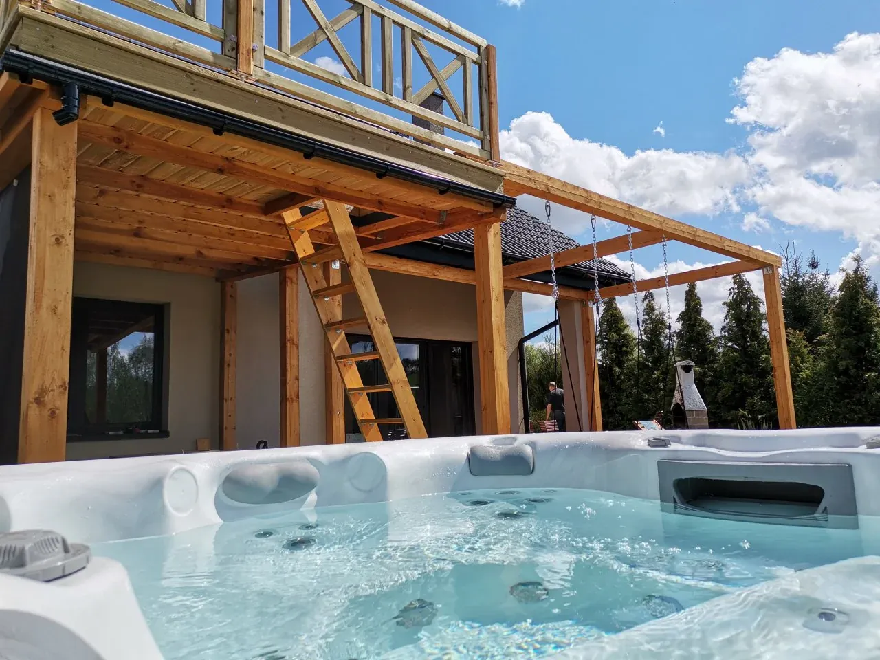 Relaks w domku spa na Mazurach. Wanna z hydromasażem czeka na gości pod drewnianą altaną.