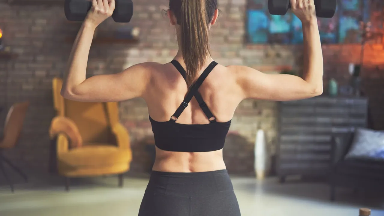 kobieta wykonująca trening siłowy, hantle