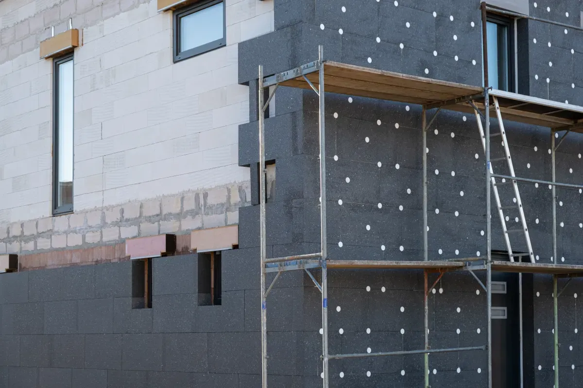 Izolacja termiczna domu, na którą można dostać dofinansowanie przy remoncie. Widać rusztowanie i styropian grafitowy.