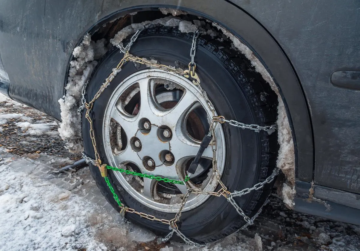 Łańcuchy na kołach samochodu w Polsce, aby uniknąć mandatu za brak łańcuch&oacute;w na ośnieżonej drodze.