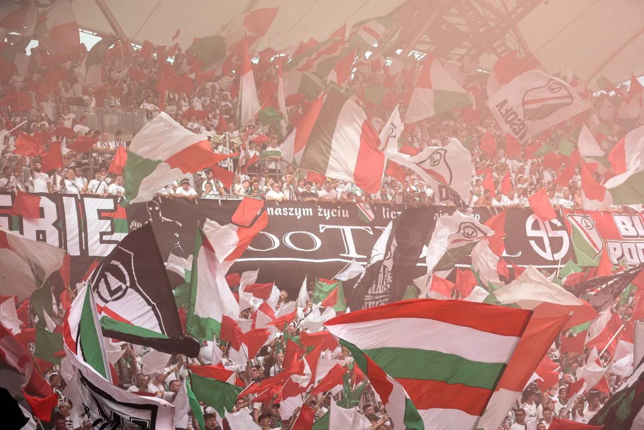 Tłum kibic&oacute;w z flagami w barwach Legii Warszawa, atmosfera ostatniej kolejki Ekstraklasy.