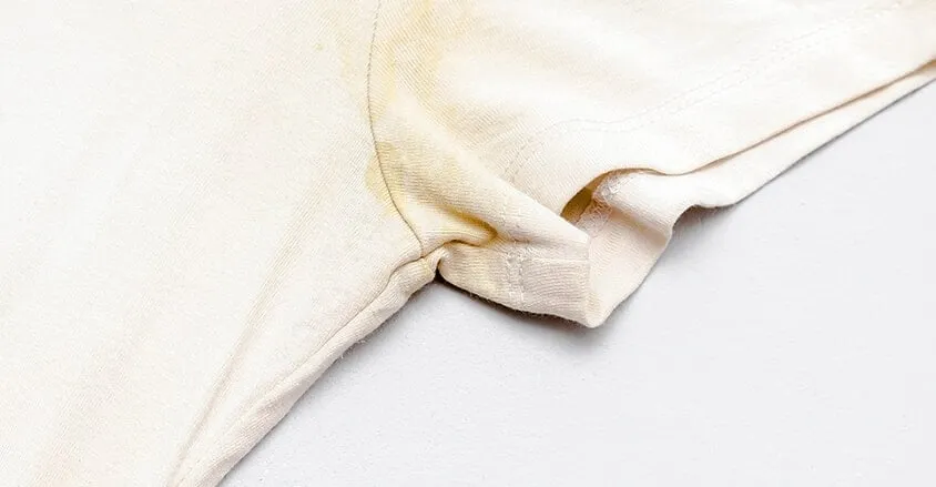 biała bluzka z żółtymi plamami potu