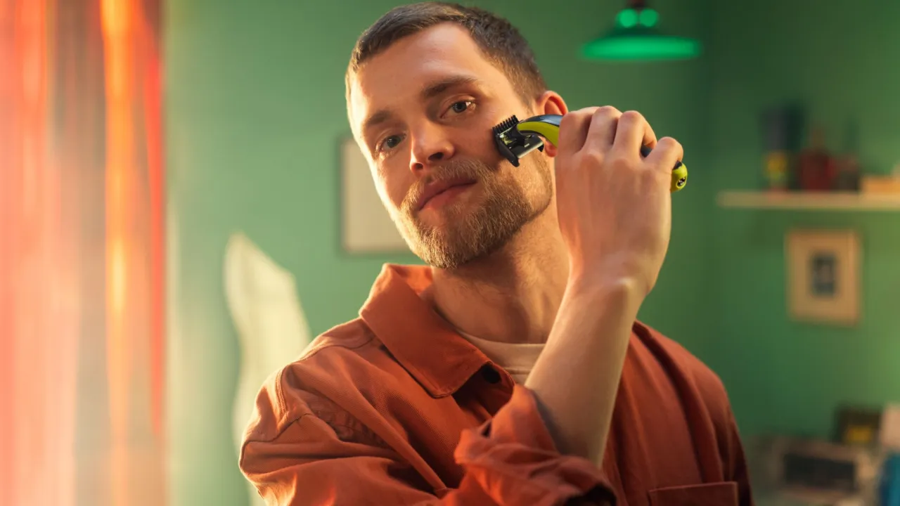 Mężczyzna przycinający brodę trymerem