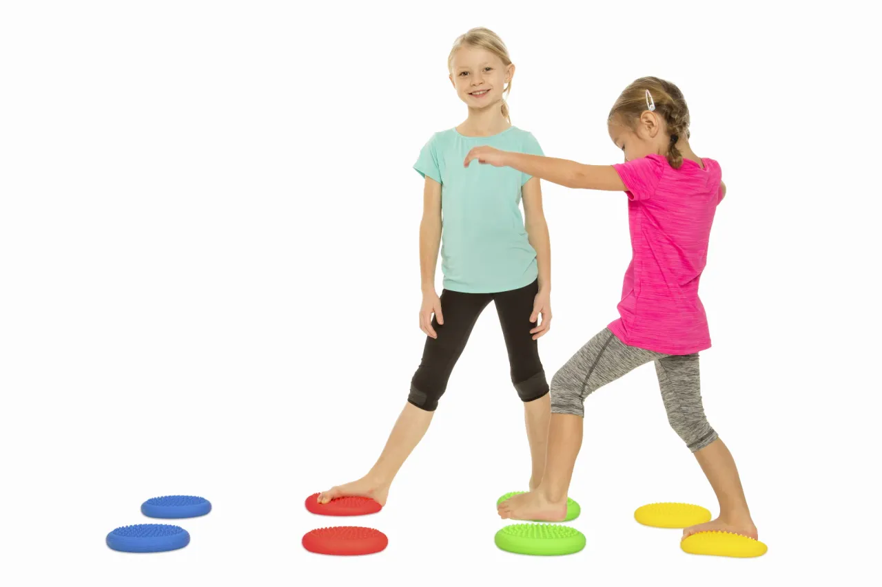 Dziecko bawiące się na dyskach sensorycznych Tullo, ćwiczenia na dyskach sensorycznych