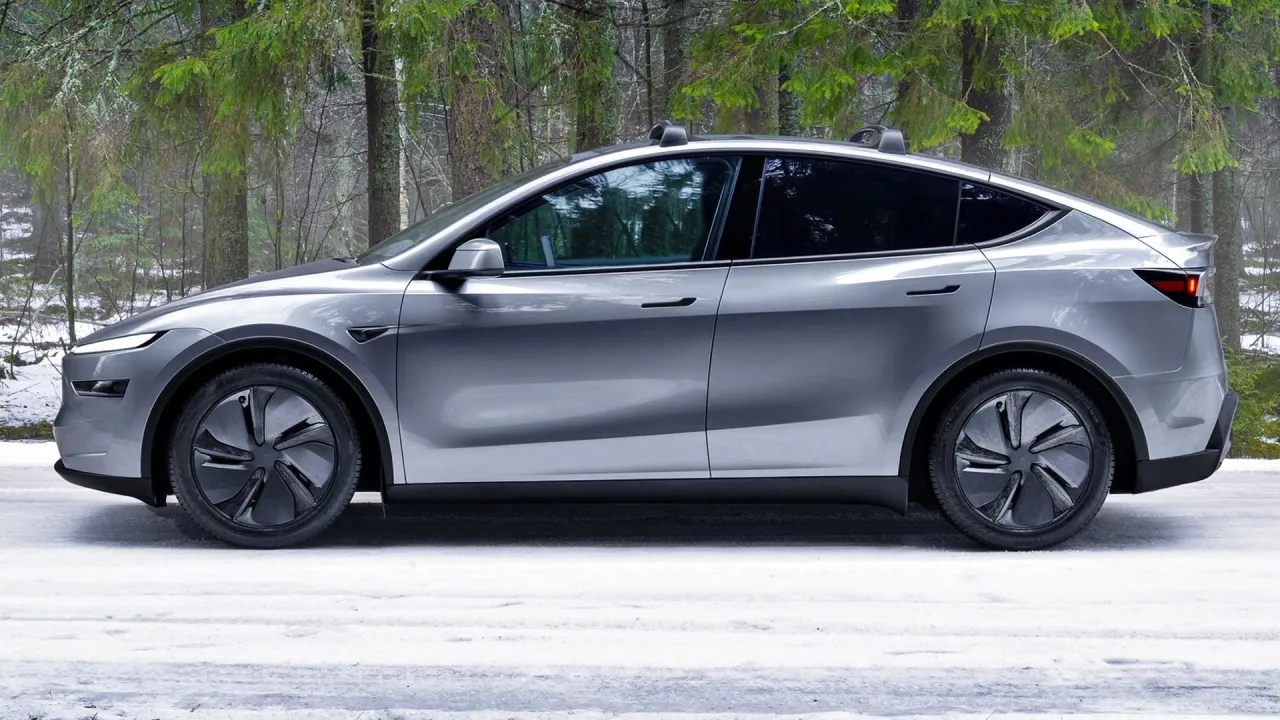 Srebrna Tesla Model Y na tle zimowego lasu. Zastanawiasz się, ile kosztuje Tesla Model Y?