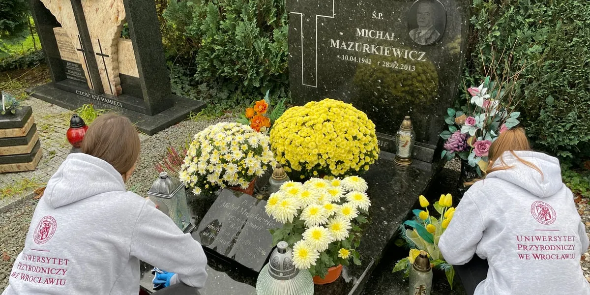 kobieta zapala znicz na grobie