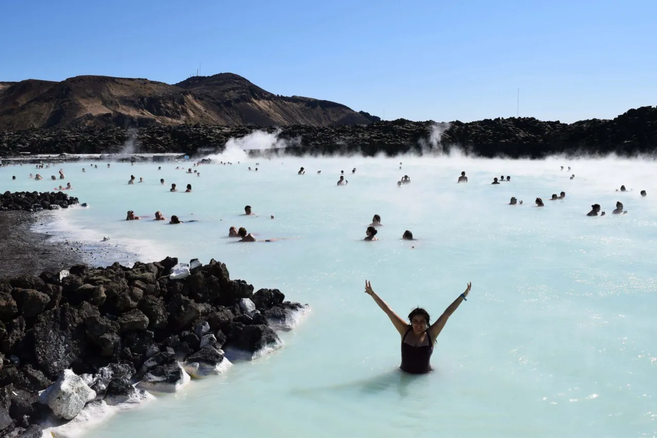 Kobieta cieszy się kąpielą w Blue Lagoon, geotermalnym basenie z mlecznobiałą wodą.