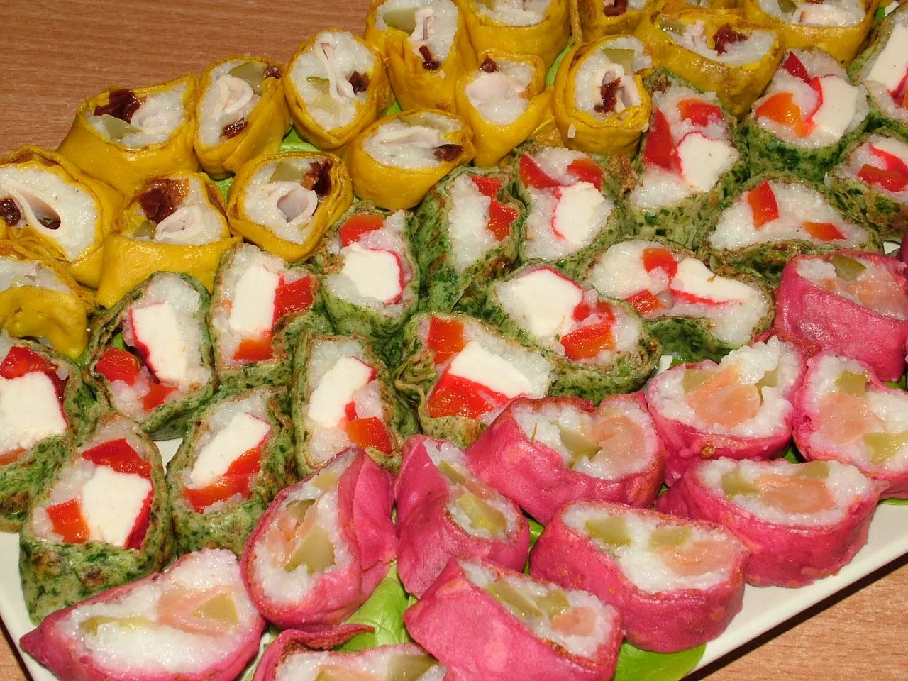 Kolorowe rolki sushi w naleśniku, z łososiem, paluszkami krabowymi i warzywami. Pyszne sushi w naleśniku nazwa.