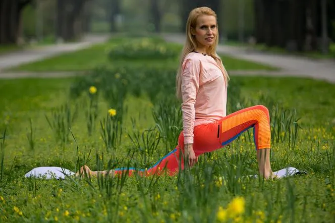 osoba rozciągająca się z uśmiechem, zwiększony zakres ruchu