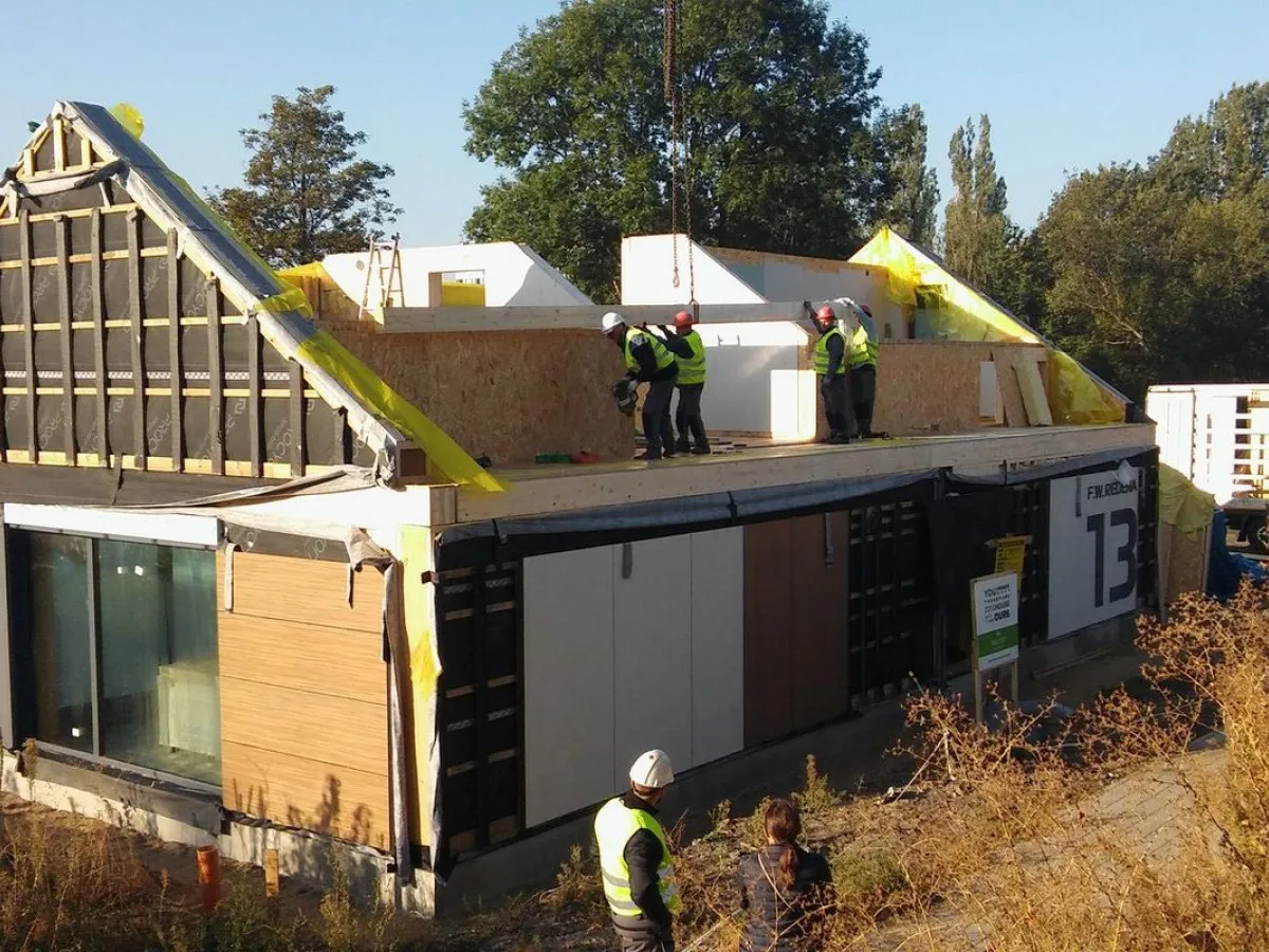 Budowa domu szkieletowego w toku. Pracownicy montują elementy konstrukcji, pokazując, ile wytrzyma dom szkieletowy.