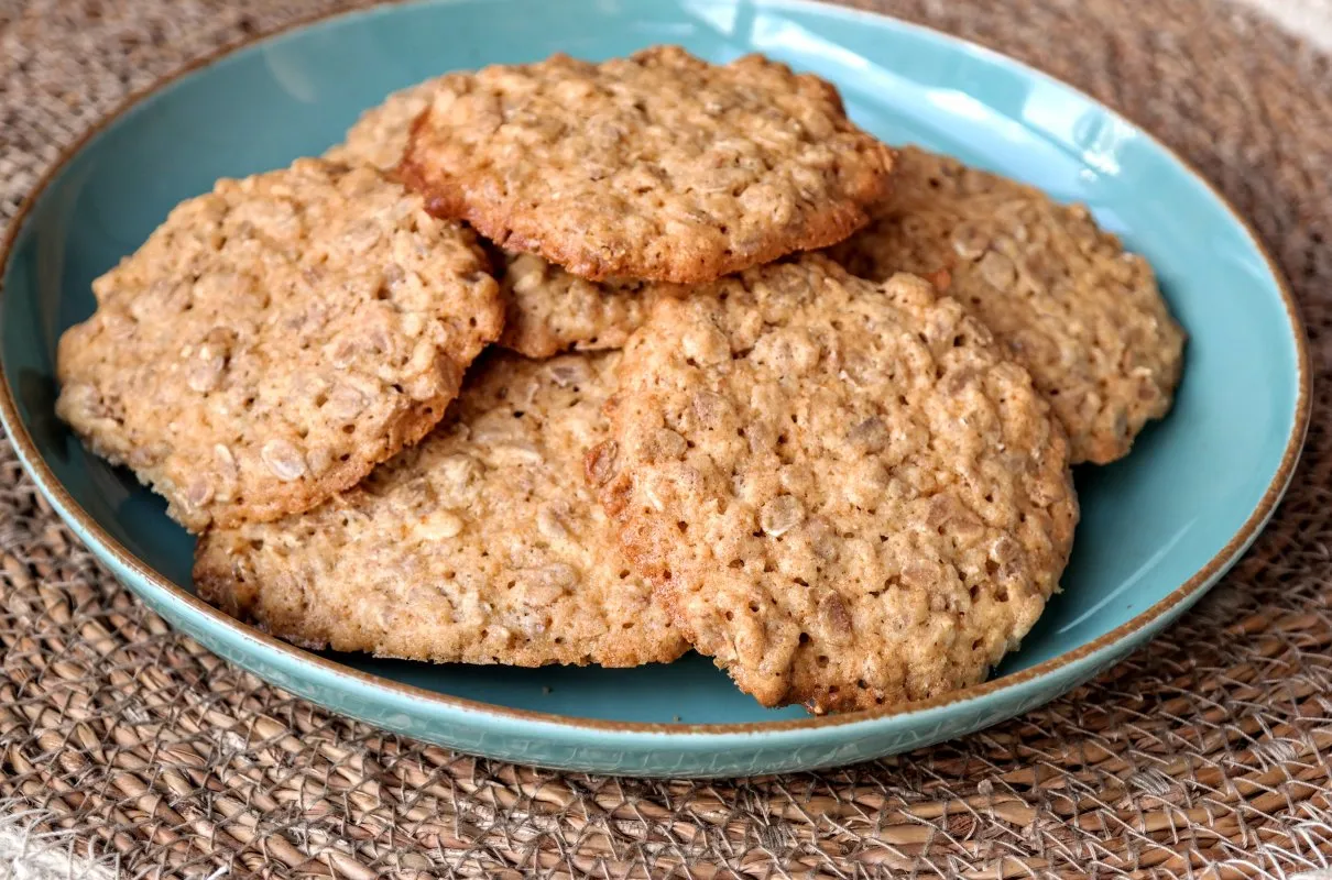 Chrupiące ciasteczka owsiane z nasionami słonecznika na turkusowym talerzu. Idealne na przekąskę.