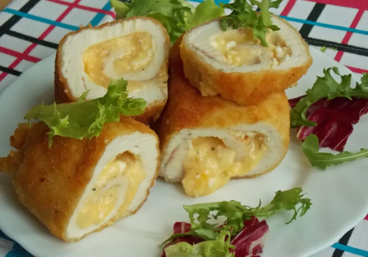 Pyszne roladki drobiowe z serem, panierowane i złociste, podane z sałatką.