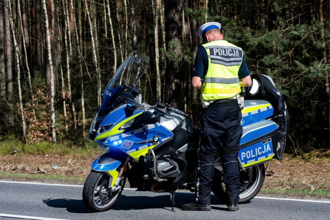 Motocykl na drodze, znak zakazu, policja