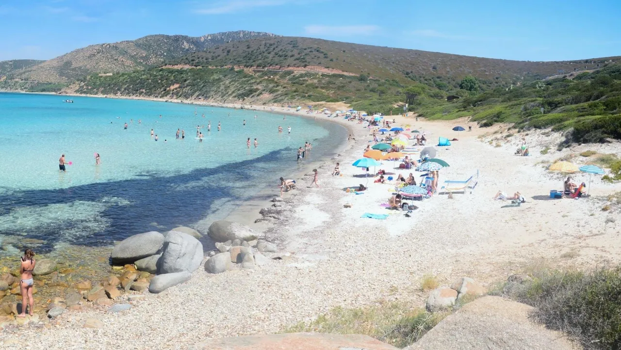 Sardynia: uważaj na słońce i tłumy na plaży. Piękna, błękitna woda i zielone wzg&oacute;rza.