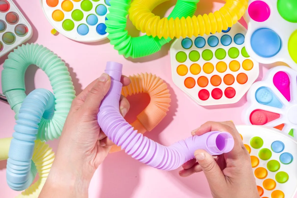 Różne rodzaje zabawek sensorycznych dla dzieci z ADHD, np. fidget toys, obciążeniowe, gryzaki