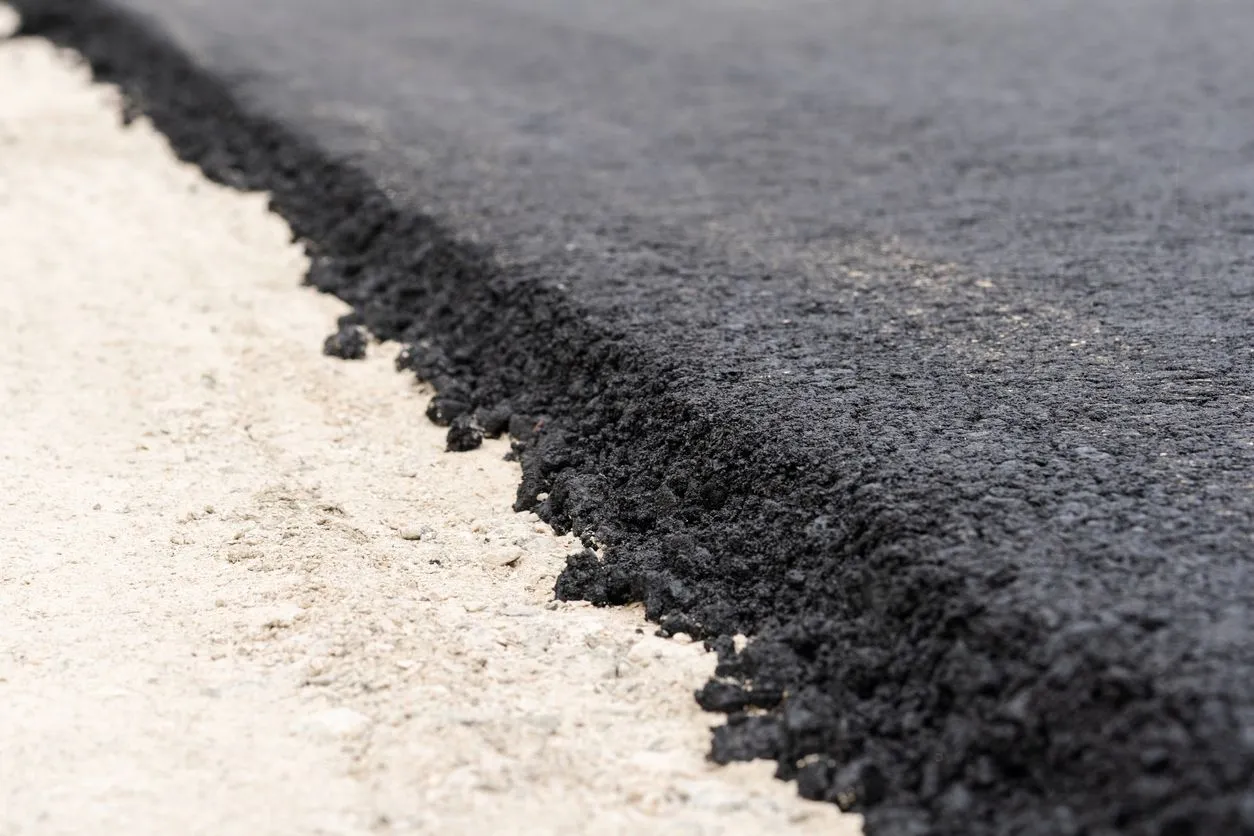 Świeżo położony asfalt na drodze. Zastanawiasz się, ile kosztuje 1m2 asfaltu?