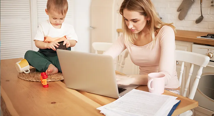 kobieta z dzieckiem przy komputerze praca macierzyński