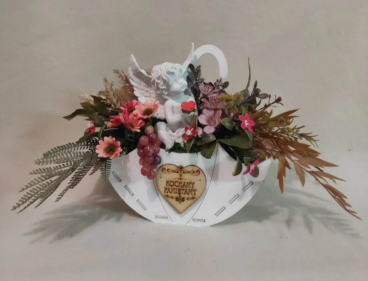 Stroik na cmentarz dla dziecka: biały aniołek z serduszkiem, kwiaty, winogrona i serce z napisem 