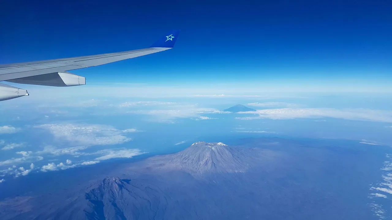 Widok z samolotu na Kilimandżaro i inne góry. Zastanawiasz się, ile godzin leci się na Zanzibar?
