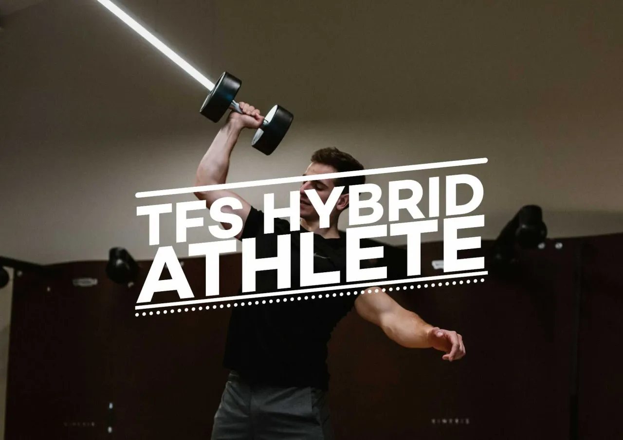 Mężczyzna podnosi hantle, pokazując, jak połączyć crossfit z siłownią. #TFS Hybrid Athlete.