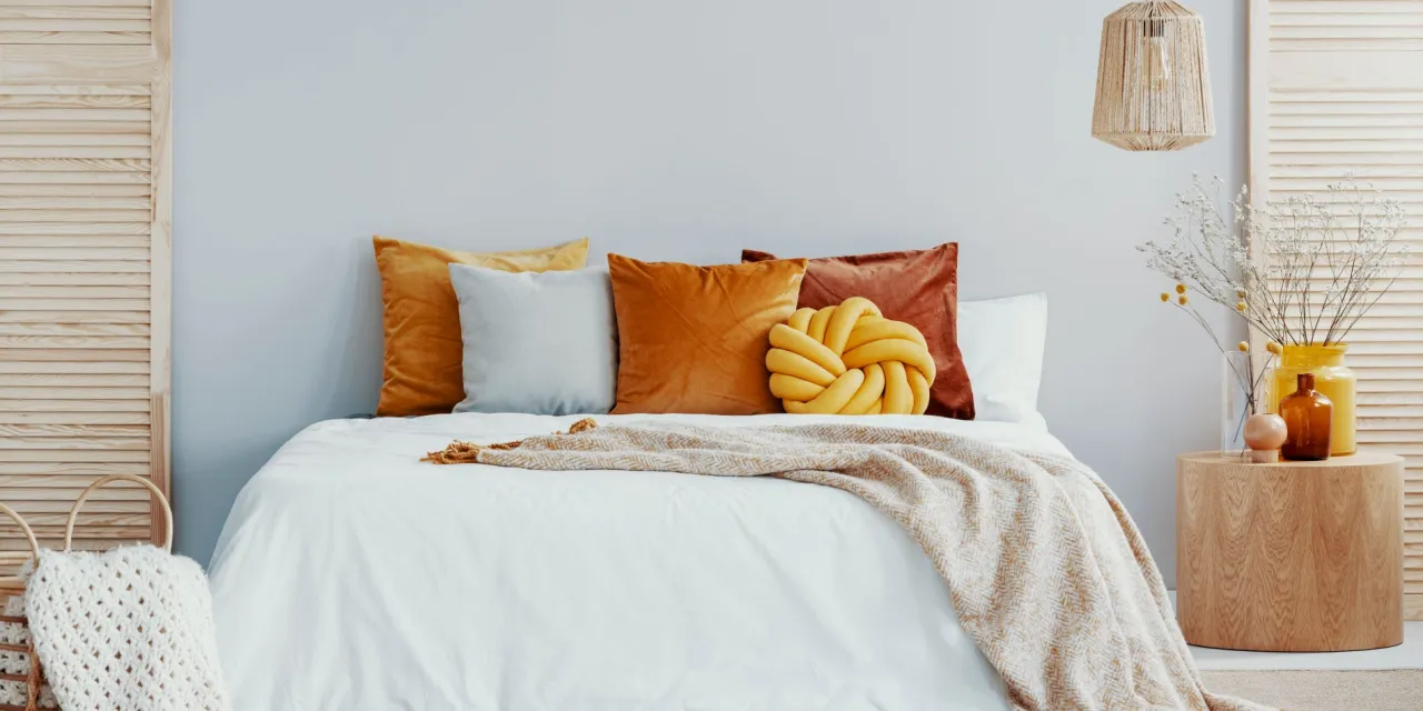 Szara sypialnia z kolorowymi tekstyliami