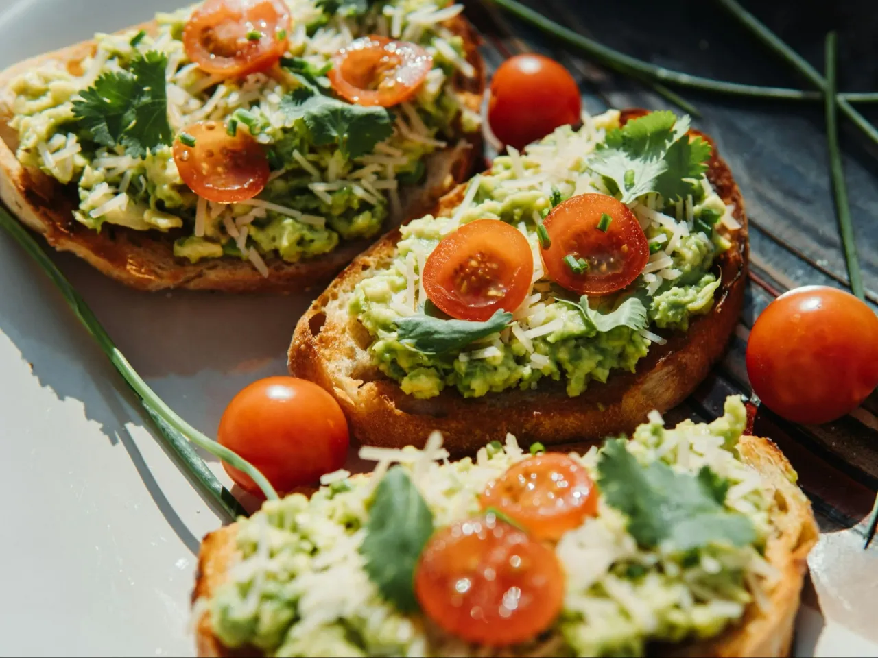 Trzy grzanki z awokado, pomidorkami koktajlowymi i serem. Zastanawiasz się, ile kalorii ma grzanka? To zależy od składników!
