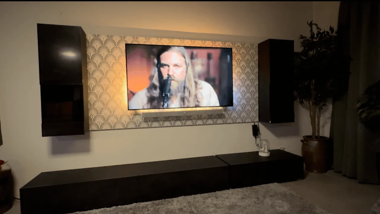 Osoba siedząca na kanapie z telewizorem na wysokości wzroku