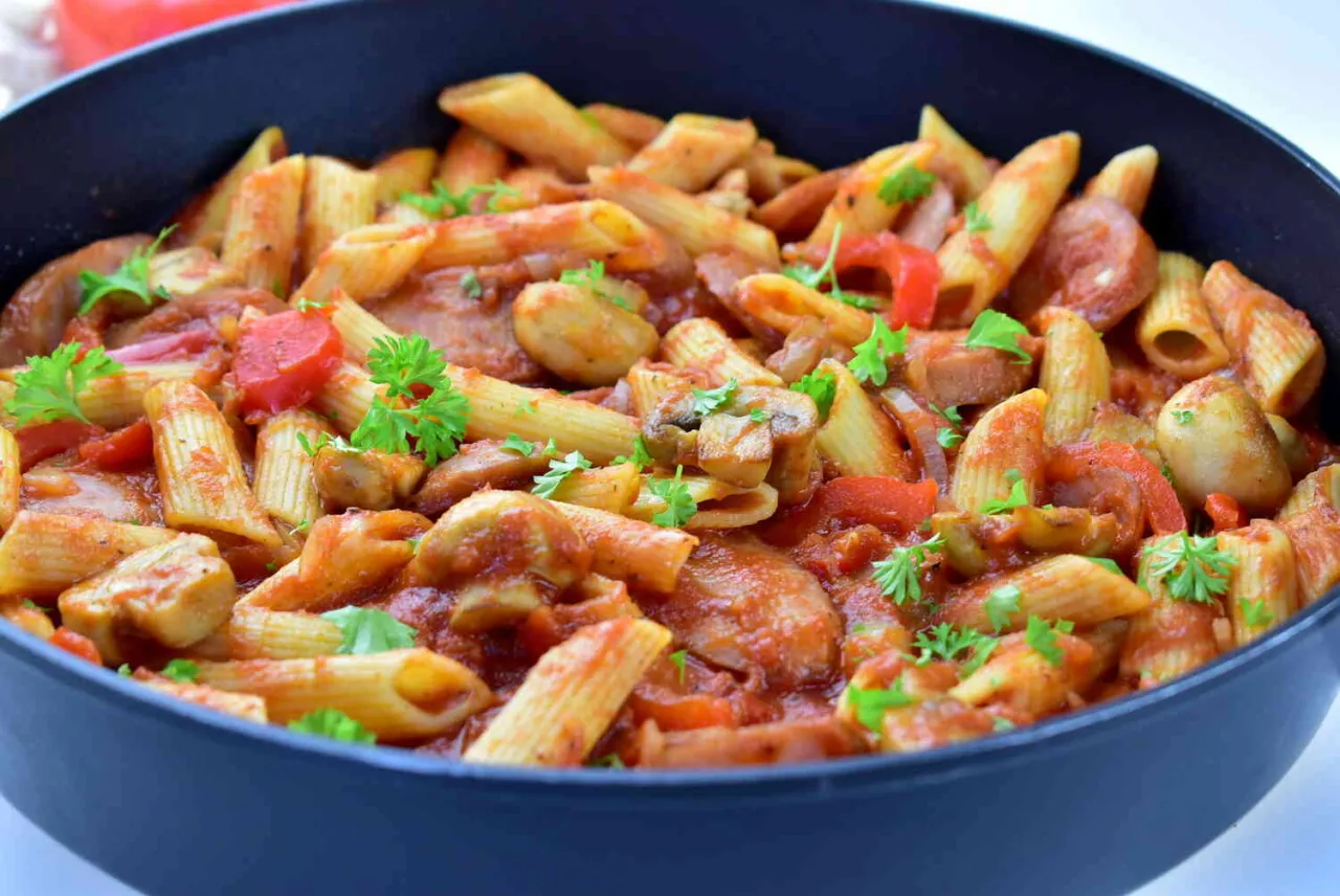 Kiełbasa w sosie pomidorowym na talerzu z dodatkami